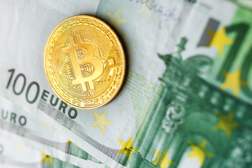 virtual money golden bitcoin on hundred euro bills background. Exchange bitcoin cash for a dollar.