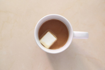 Top view of hot coffee or chocolate cup with marshmallow inside.