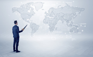 Fototapeta na wymiar Businessman standing with his back and looking at a worldwide map with objects in his hand 