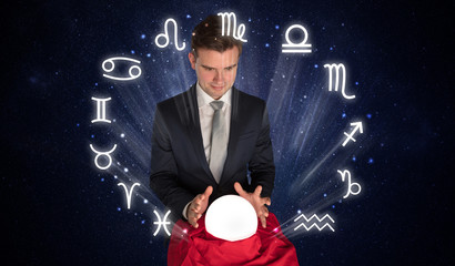 Young handsome astronaut looking for inspiration in his crystal magic ball
