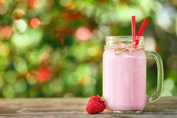 strawberry milkshake in mason jar on table