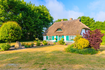 Fototapeta na wymiar Traditional house with straw roof in and sunny blue sky near Ostseebad Sellin, Ruegen island, Baltic Sea, Germany
