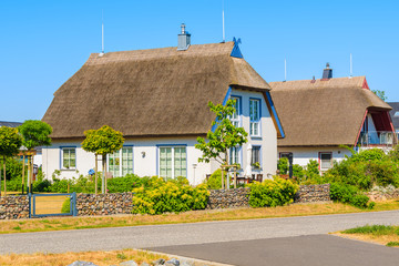 Traditional thatched roof houses on street in Gross Zicker village on sunny summer day, Ruegen...