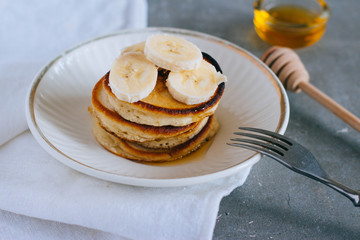 Delicious pancakes with banana and honey on a breakfast