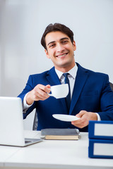 Young handsome businessman employee working in office at desk