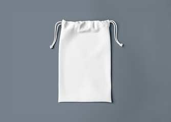 White drawstring bag on dark background. Fabric cotton small bag. Isolated pouch.