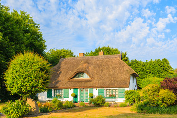 Fototapeta na wymiar Traditional house with straw roof and sunny blue sky near Seedorf village, Ruegen island, Baltic Sea, Germany