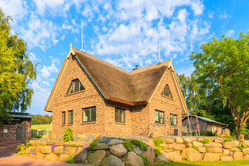 SEEDORF VILLAGE, RUEGEN ISLAND - JUN 2, 2018: Traditional thatched roof house near Seedorf village, Baltic Sea, Germany. Rugen is popular tourist destination due to its rural landscape.