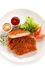 Fried pork chop and vegetable salad on white background