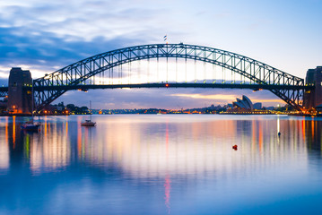 Fototapeta na wymiar Mighty construction of harbor harbour bridge during sunset sky to downtown city center centre Sydney for holiday and couple romantic honeymoon