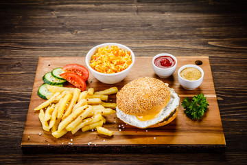 Tasty burger with chips served on cutting board