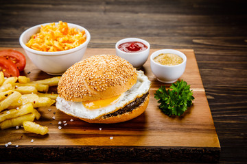 Tasty burger with chips served on cutting board