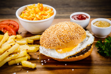 Tasty burger with chips served on cutting board