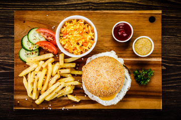 Tasty burger with chips served on cutting board
