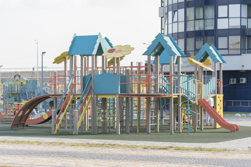 Fototapeta na wymiar Modern children's playground near high-rise buildings