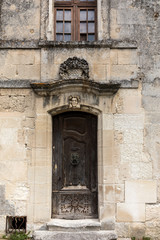 Fototapeta na wymiar Old wooden door on stone house in Les Baux de Provence, France