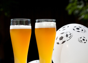 two glasses of beer and balloon with footballs - watching soccer