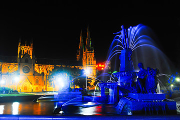 Obraz premium Water fountain in city centre center hyde park downtown Sydney with cathedral church on the background in the evening night for holiday