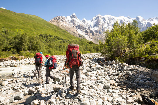 Hiking in beautiful mountains. Group of hikers enjoy sunny weather