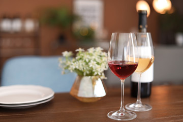 Glasses and bottle with tasty wine on table in restaurant