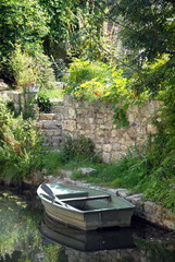 Barque au bord de l'eau, vieux muret en pierre et verdure, Chartres, Eure et Loir, France