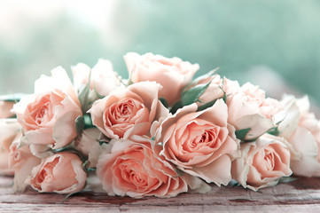 several pink roses on a wooden table