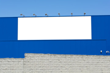 Blank billboard on brick and blue wall, banner edge and grommets preserved for a more realistic look - obrazy, fototapety, plakaty