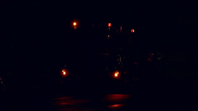 Three orange flashers spinning and flashing on roof of gas-repair service truck with blinking spot lights in the night.