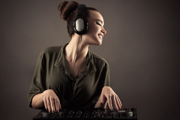 beautiful girl behind DJ remotes in headphones 