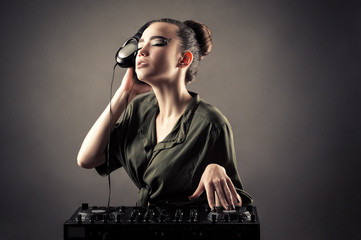 charming girl behind DJ remotes in headphones 