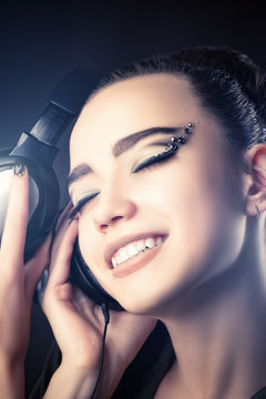 beautiful smiling girl listening music through headphones 