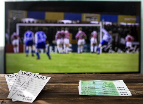 On the TV there is a league of champions on football on a table bookmaker's tickets and euro, rates on sports