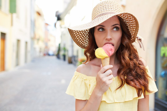 Fototapeta pretty girl with ice cream is walking on Italian streets