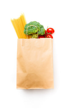 Photo of paper bag with broccoli, spaghetti and tomatoes
