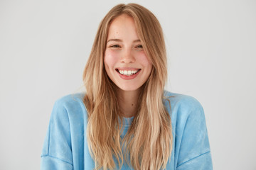 Optimistic lovely woman with charming sincere smile, being in good mood, rejoices starting new...