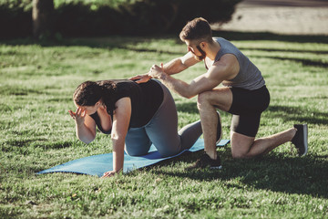 Street workout, motivation, sport, outdoor activity, healthy lifestyle concept. Personal trainer motivation. Overweight woman training with fitness instructor support