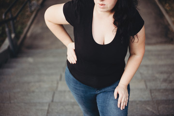 Overweight woman suffering from breathe shortness stepping on stairs. Excess weight, heart...