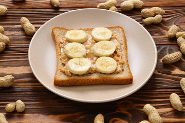 Peanut butter toast with banana slices  on wooden background