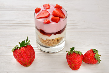 Home made granola breakfast with strawberries and plain yogurt, served in the glass.