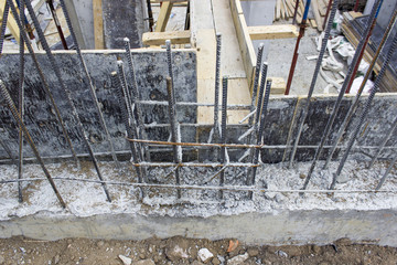 Upper shot of new textured iron sticks in concrete column at construction site