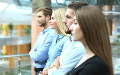 Business team standing in a row at office and looking upwards.