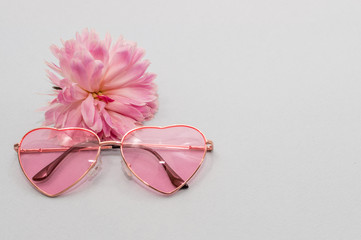 rose-colored glasses and a pink peony bud. concept summer