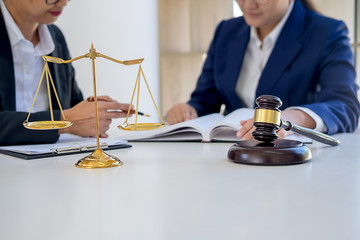 Judge gavel with Justice lawyers having team meeting at law firm in background. Concepts of law.