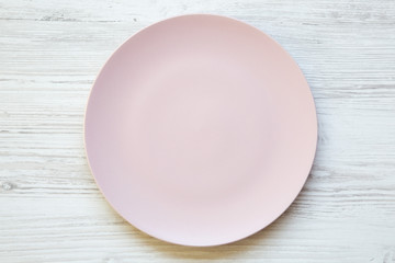 Empty pink plate on white wooden background. Top view, from above, flat lay. Dieting concept.