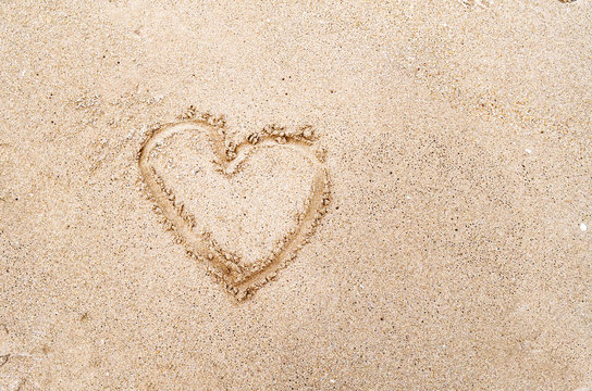 Heart drawn in the sand on the Beach background. Top view photo and space for text, love and valentine day concept