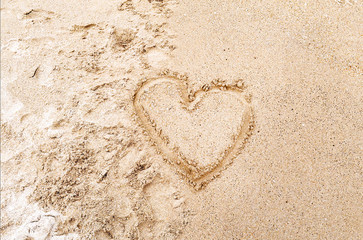 Heart drawn in the sand on the Beach background. Top view photo and space for text, love concept