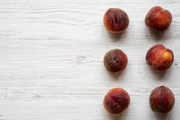 Fresh peaches on white wooden table, top view. Copy space.