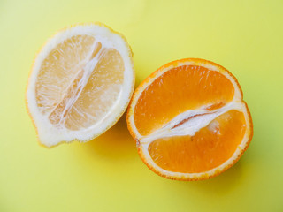 Orange and lemon close-up against a yellow background