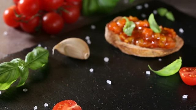 Eating Homemade Italian antipasto called Bruschetta topped with tomatoes, garlic, red pepper and basil 