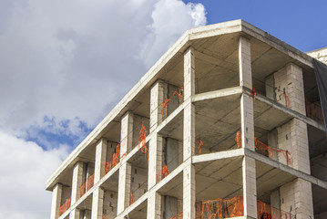 Perspective shot of colorful construction of a new reinforced concrete building with open blue sky